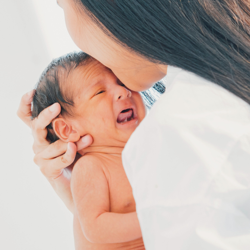 infant with tongue tie crying and being comforted